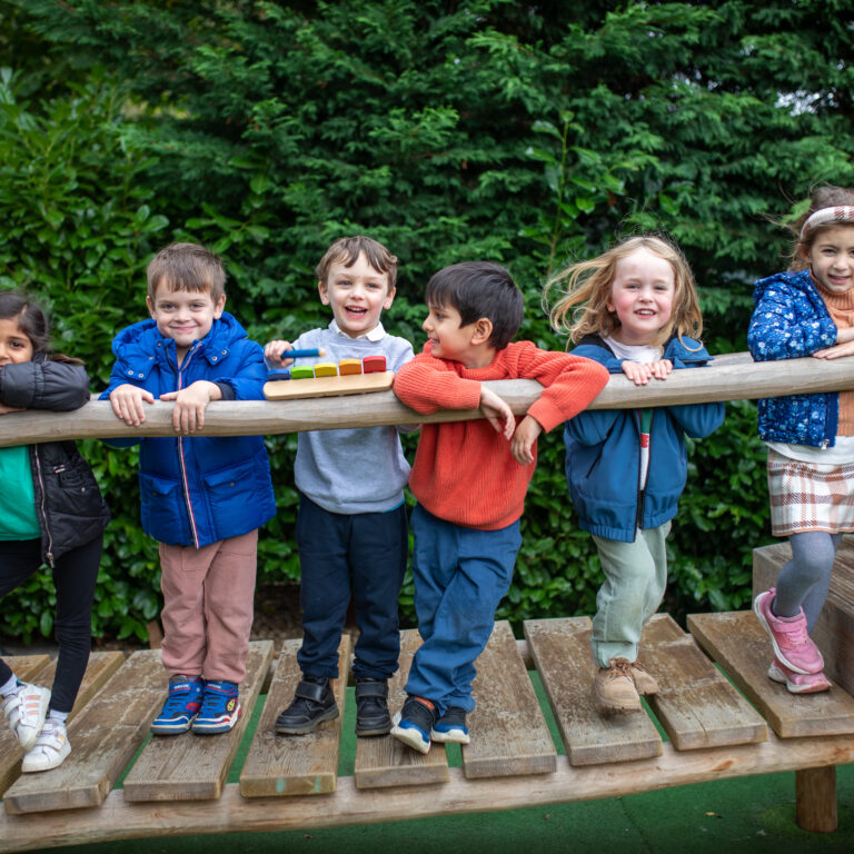 pre-prep aged children lined up on a climbing frame