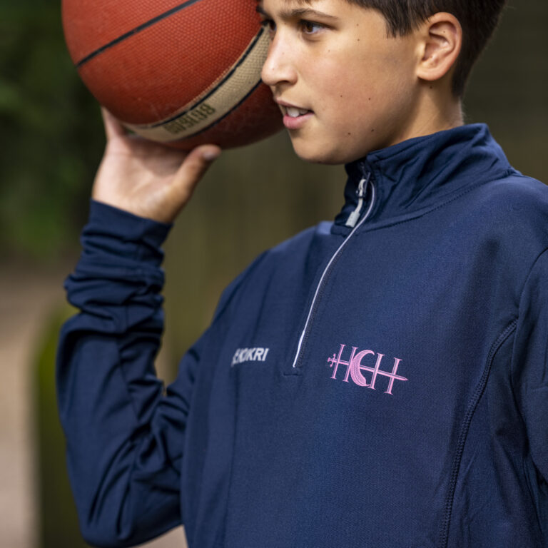 a school boy holding up a basketball