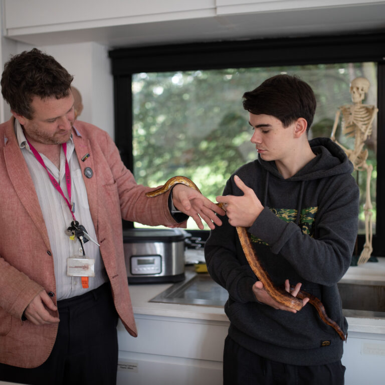 teenage boy and teacher holding a snake
